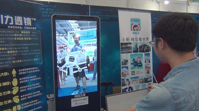 体验者将实体商品包装靠近“引力透镜”大屏展现商品3D立体模型